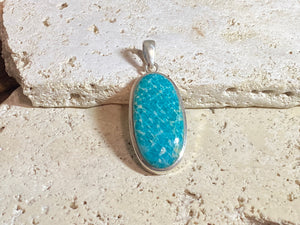 This unusual blue amazonite pendant is set off by a sterling silver bezel, topped by a bail that’s large enough to accommodate a thick chain or cord. A stunning piece of amazonite with a very unusual colour.