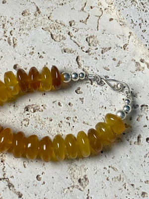 A beautiful necklace of polished graduated caramel onyx beads. Sterling silver clasp and detailing. This statement necklace is designed to impress, with the look of high quality amber without the price tag. length 51.5 cm