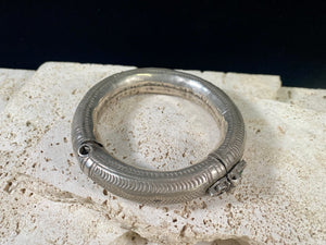 Women's antique tribal anklet, hollow construction, made in a round rigid style with a hinged opening. Very high grade silver, with repeating decoration around all sides and a decorative hinge. From Rajasthan, India. Late 19th century or older.