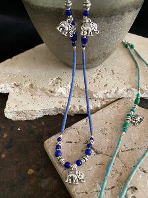 Beaded stone elephant necklace in either turquoise or lapis blue, each featuring three small elephant charms. This beautiful stone necklace is indistinguishable from much more expensive sterling silver and natural turquoise or lapis necklaces. This is unisex jewellery that can be worn either as a bracelet or as a necklace