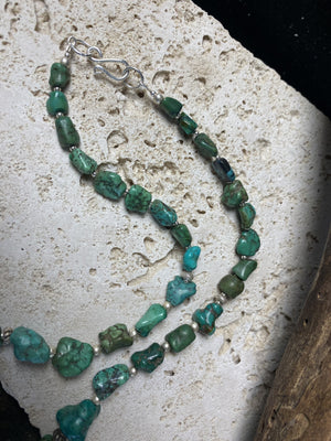 A unique necklace crafted from graduated antique Tibetan turquoise and vintage silver beads, highlighted with sterling silver spacer beads. These beautiful natural stones range in colour from mid to dark blue-green and are all antiques in their own right. The best turquoise we've ever found. This long tribal necklace can be worn by either men or woman. Total length 62.7 cm