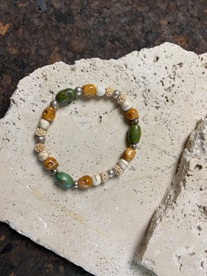 Stretchy bracelet featuring hand carved yak bone skulls, natural antique Tibetan turquoise, undyed howlite , carved lotus root and sterling silver beads. Designed to fit on a wrist 11-14 cm circumference