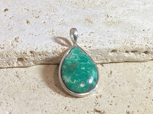 This strong green turquoise teardrop pendant is set off by a sterling silver bezel, topped by a bail that’s large enough to accommodate a thick chain or cord. Can be worn by men or women. A stunning piece of turquoise from Tibet.