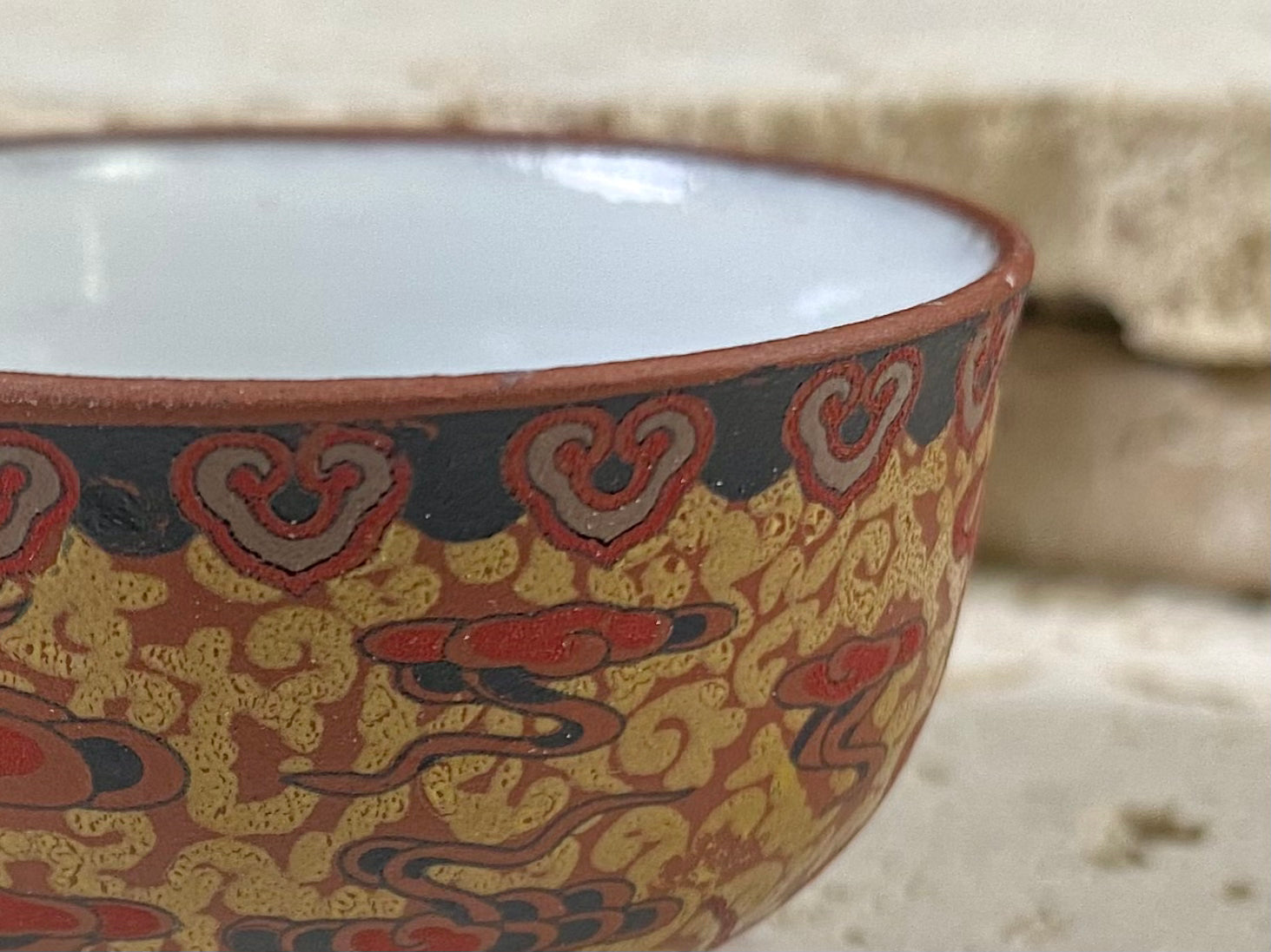 These tiny tea bowls are made from fired clay, glazed on the inside and beautifully decorated on the outside with a pattern of cloud spandrels. Stamped with the makers mark on the base. From Nepal.  As well as tea bowls, these make beautiful miniature offering bowls and when filled with sand, are perfect for holding incense sticks in the Chinese style.  Measurements: 3 cm height, diameter at top 5 cm