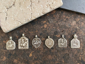 Antique silver amulets that represent Baba Ramdev (Ramdevshi), a legendary Rajput warrior who went about doing deeds of goodness and valour. These small pendants are traditionally worn for protection and good luck and date from the early 19th - early 20th century. Measurements: all vary between 1.5 and 1.7 cm in width