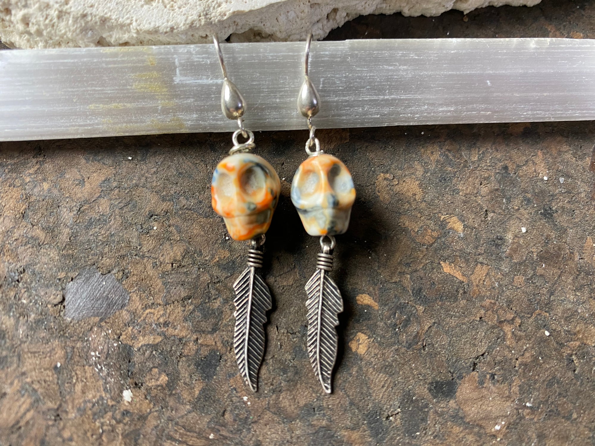 Skull jewelry. Hand carved jasper skull earrings feature sterling silver hooks and feather dangles. 