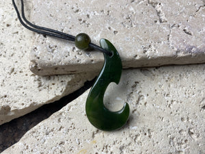 Natural green jade hei matau fish hook pendant, hand carved in New Zealand by a Maori craftsman.