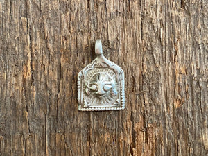 Antique silver amulets representing the Hindu god Shiva, traditionally worn for protection and good luck. Originating in southern India and dating from the late 19th century.
