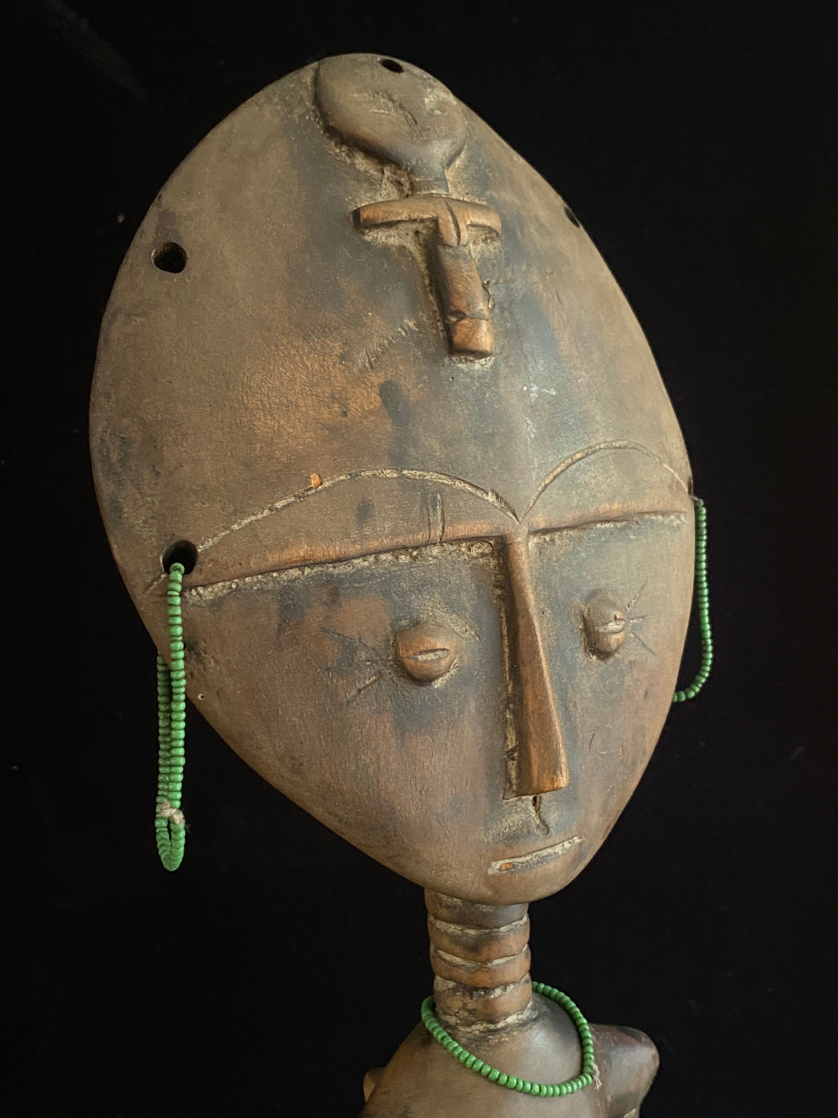 Akuaba or Aquaba Doll, Asante, from Ghana. Mid 20th Century, vintage fertility idol with carved neck rings and beaded decoration and carries a smaller, more traditional akuaba figure on her forehead. She is detailed on the back, wearing a carved baby carrier. Height 45.5 cm