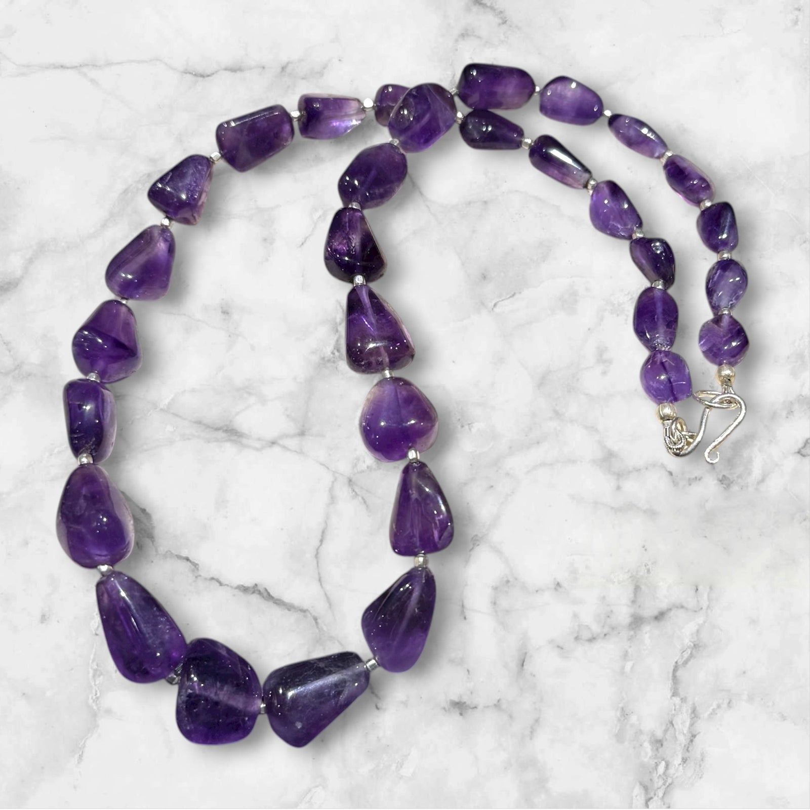 Striking but simple graduated boulder amethyst necklaces with sterling silver bead detailing, finished with a sterling silver hook clasp.