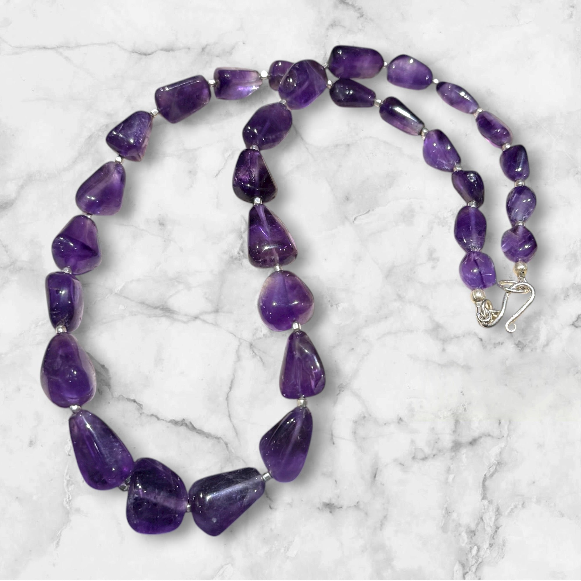 Striking but simple graduated boulder amethyst necklaces with sterling silver bead detailing, finished with a sterling silver hook clasp.