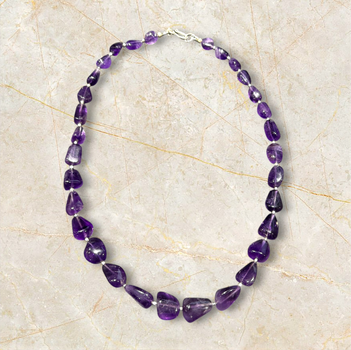 Striking but simple graduated boulder amethyst necklaces with sterling silver bead detailing, finished with a sterling silver hook clasp.