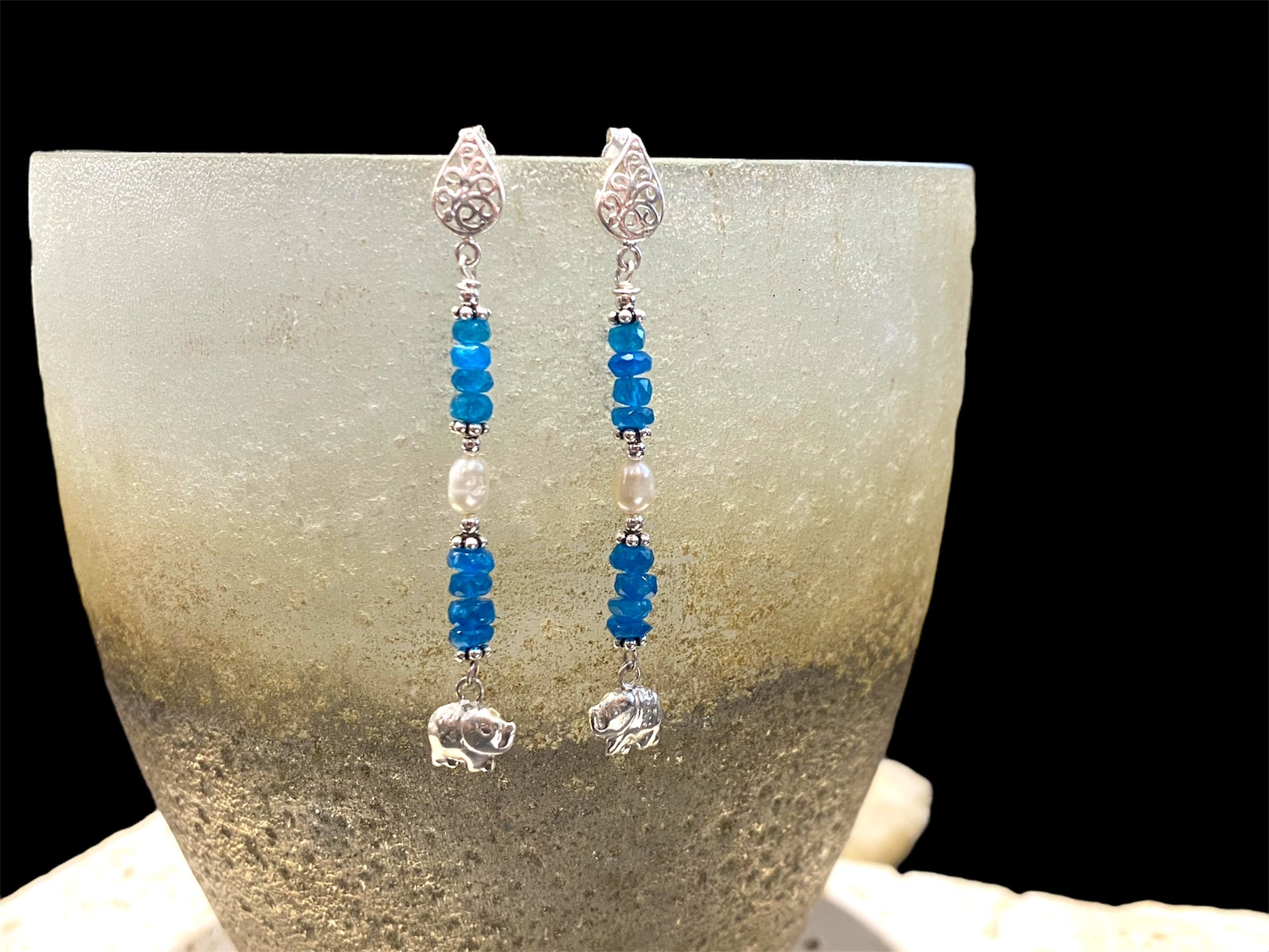 Apatite earrings with pearl detailing, finished with sterling silver elephant charms. Sterling post and butterfly mount. Measurements: 6 cm height