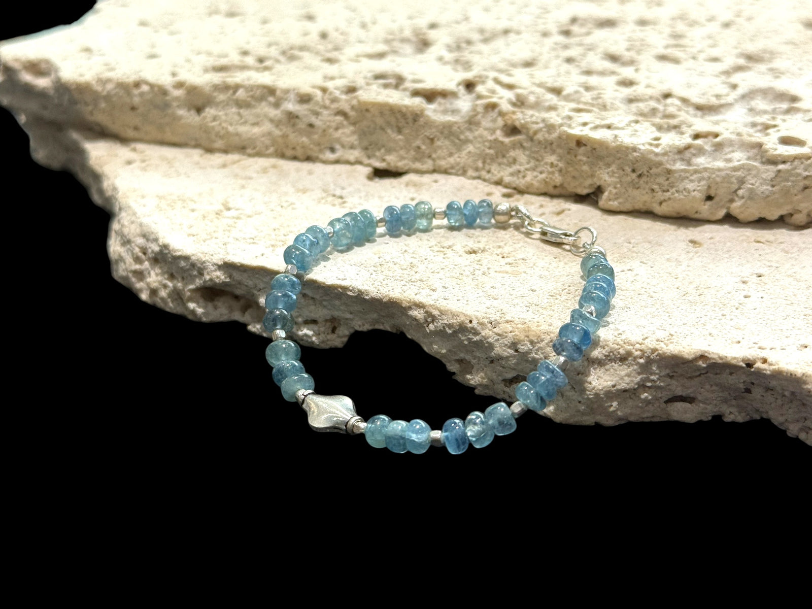 Fine beaded bracelet of aquamarine rondel beads, with a sterling silver feature bead, spacer beads & clasp. Length 16.5 cm, size 14 cm. Centre silver bead 1 cm