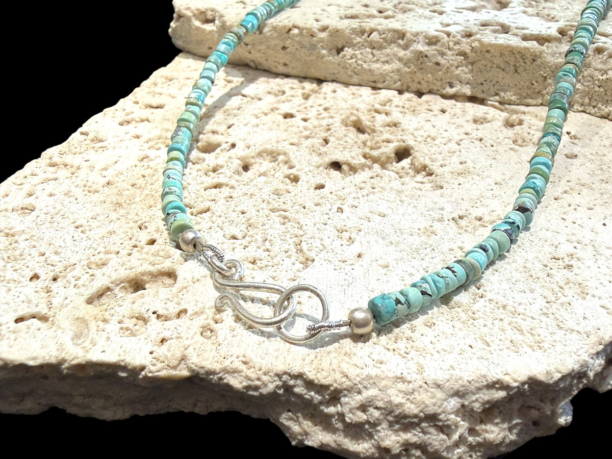 Graduated turquoise choker necklace featuring heshi beads of pale blue Arizona turquoise. Finished with a sterling silver hook clasp. 41 cm (16.25") length