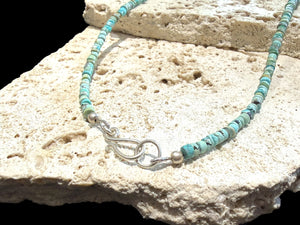 Graduated turquoise choker necklace featuring heshi beads of pale blue Arizona turquoise. Finished with a sterling silver hook clasp. 41 cm (16.25") length