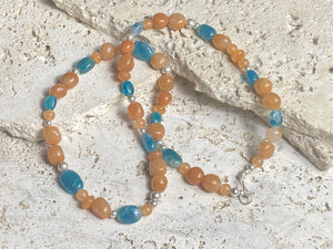 Asymmetrical necklace of deep blue apatite beads strung with red-orange aventurine and sterling silver. Sterling silver hook clasp. Measurements: 60 cm length