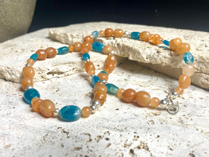 Asymmetrical necklace of deep blue apatite beads strung with red-orange aventurine and sterling silver. Sterling silver hook clasp. Measurements: 60 cm length