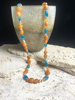 Asymmetrical necklace of deep blue apatite beads strung with red-orange aventurine and sterling silver. Sterling silver hook clasp. Measurements: 60 cm length