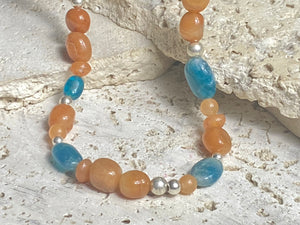 Asymmetrical necklace of deep blue apatite beads strung with red-orange aventurine and sterling silver. Sterling silver hook clasp. Measurements: 60 cm length