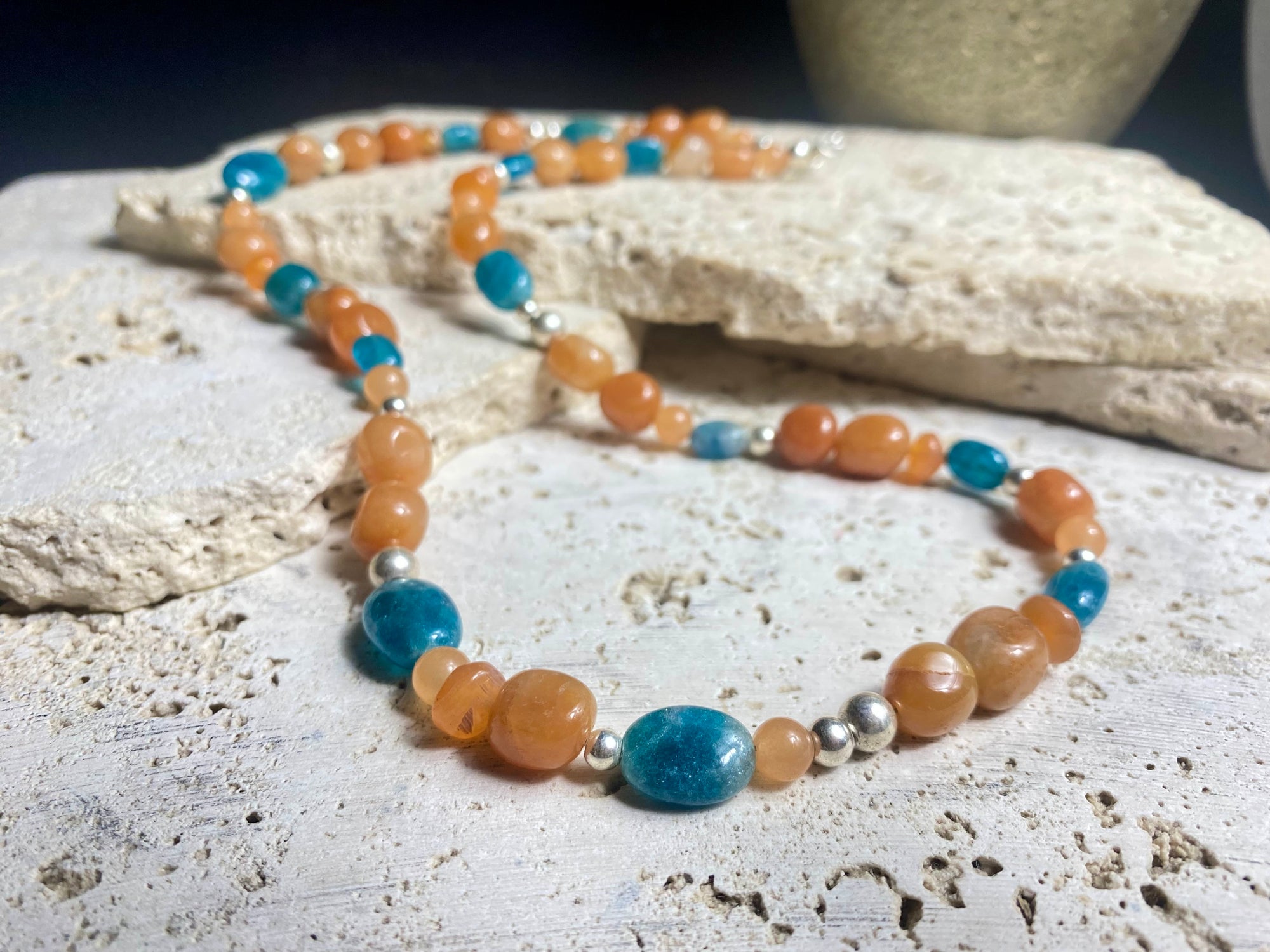 Asymmetrical necklace of deep blue apatite beads strung with red-orange aventurine and sterling silver. Sterling silver hook clasp. Measurements: 60 cm length