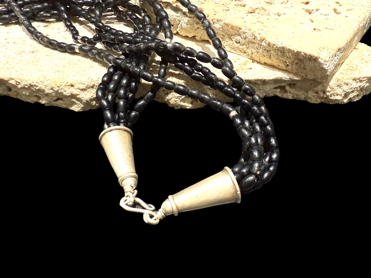 One of the oldest necklaces collected by Kashgar founder Bernie Heaphy, we've remade these strands into a very wearable necklace. Made by the Naga people of northeast India, these black ceramic beads have been teamed with sterling silver highlights and heavy sterling silver cone ends. Measurements: 57 cm length