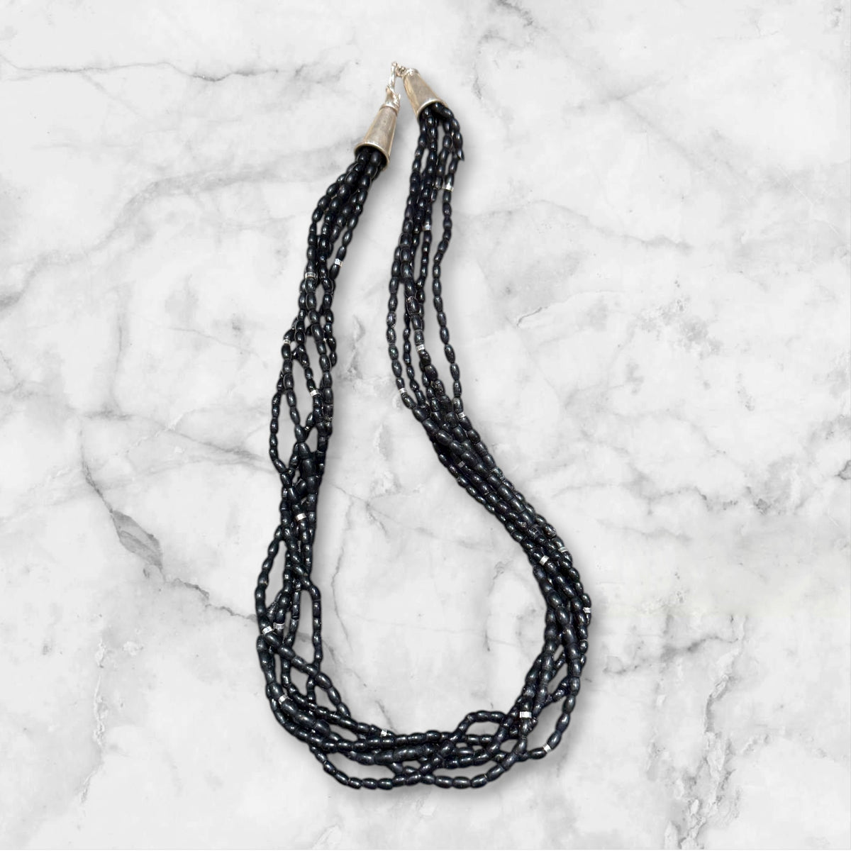One of the oldest necklaces collected by Kashgar founder Bernie Heaphy, we've remade these strands into a very wearable necklace. Made by the Naga people of northeast India, these black ceramic beads have been teamed with sterling silver highlights and heavy sterling silver cone ends. Measurements: 57 cm length
