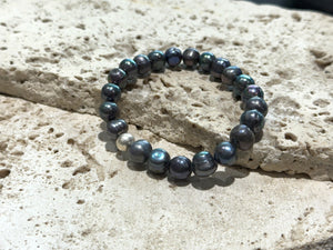 A simple and elegant bracelet of large black freshwater pearls and a single sterling silver bead. Elasticised stringing for a seamless look.