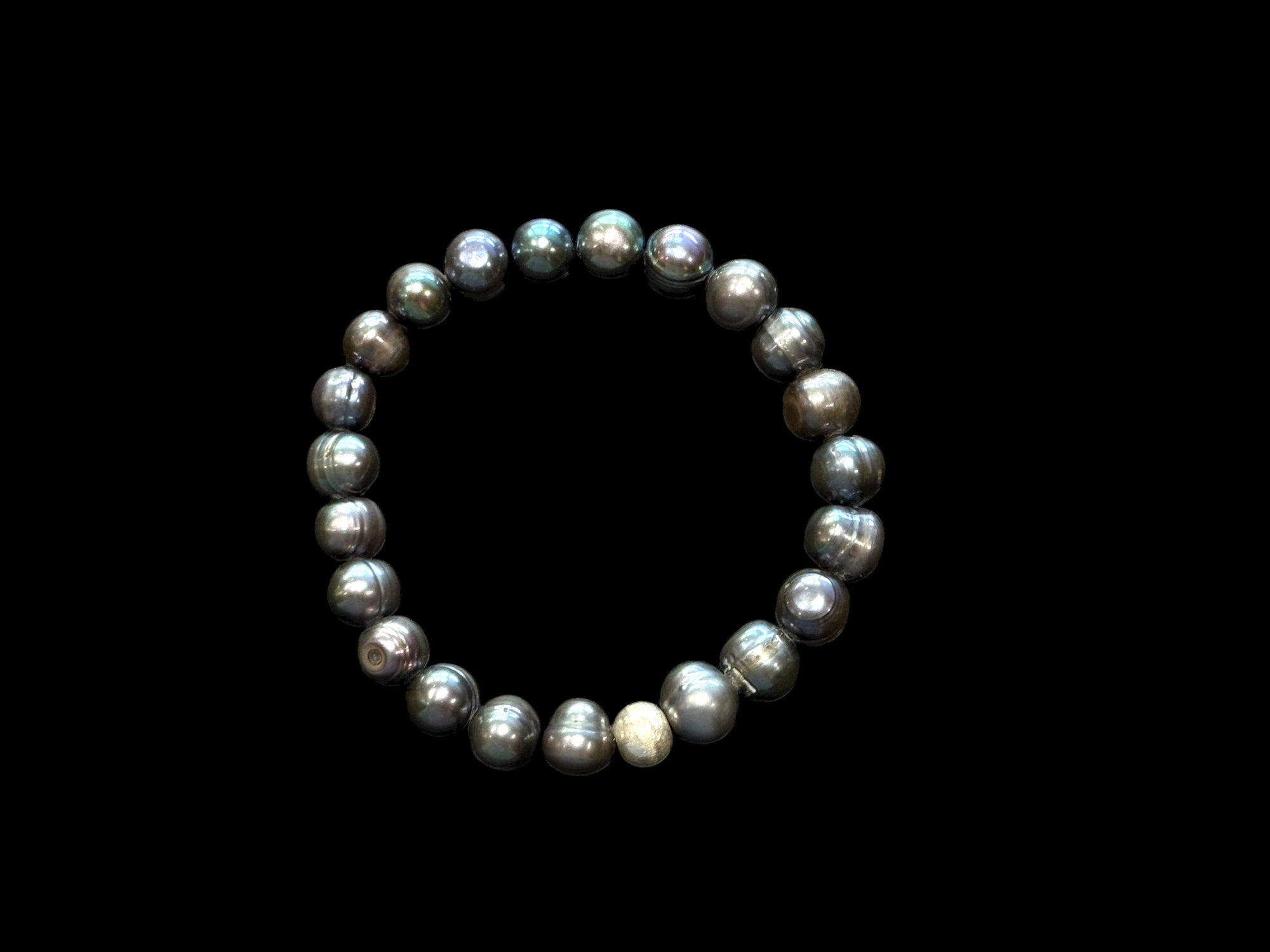 A simple and elegant bracelet of large black freshwater pearls and a single sterling silver bead. Elasticised stringing for a seamless look.