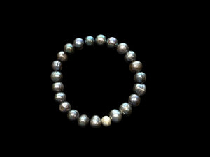 A simple and elegant bracelet of large black freshwater pearls and a single sterling silver bead. Elasticised stringing for a seamless look.