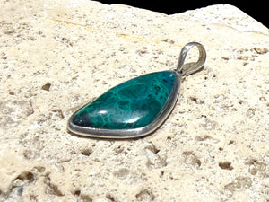 Blue green chrysocolla pendant set off by a sterling silver bezel and bail. Height 5 cm, 2.1 cm at widest point