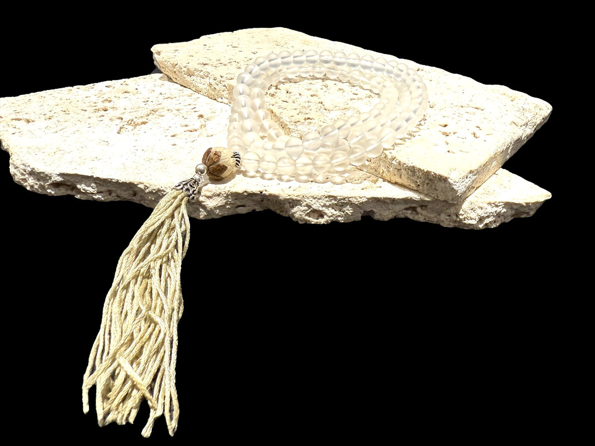 Mala prayer bead necklace of 108 beads. Crystal beads are highlighted with a carved lotus root and sterling silver tassel. 80 cm length, pendant 13 cm.