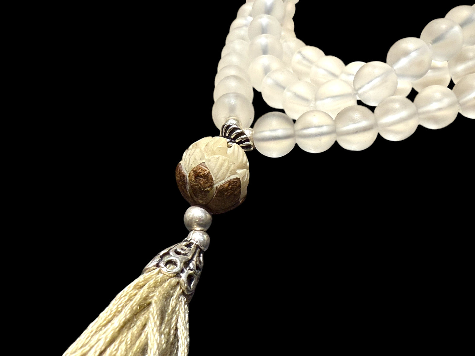 Mala prayer bead necklace of 108 beads. Crystal beads are highlighted with a carved lotus root and sterling silver tassel. 80 cm length, pendant 13 cm.