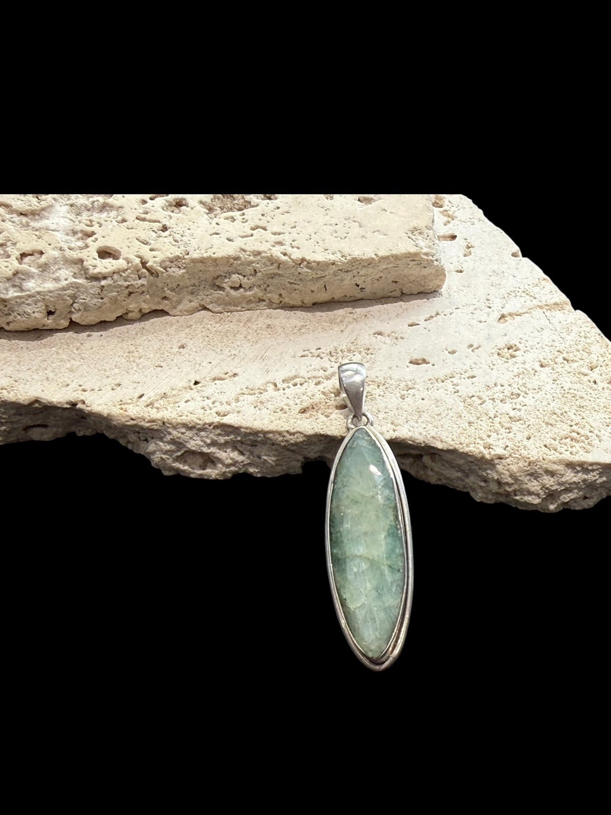 Long emerald pendant, frosted light green colour, facet cut, set in a shadow box mounting of sterling silver. Large bail. Height 6 cm, width 1.7 cm.