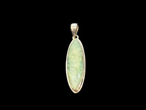 Long emerald pendant, frosted light green colour, facet cut, set in a shadow box mounting of sterling silver. Large bail. Height 6 cm, width 1.7 cm.