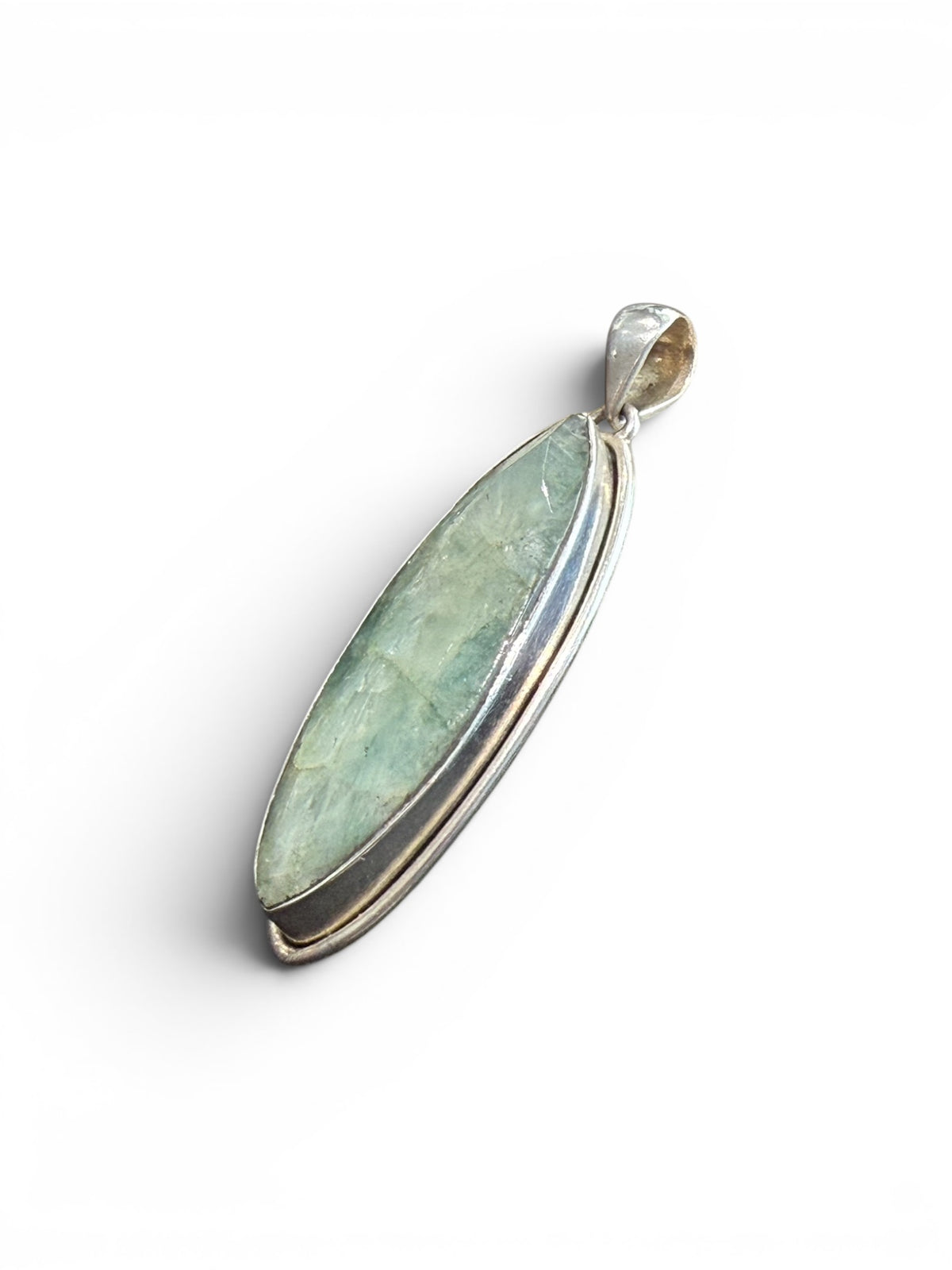 Long emerald pendant, frosted light green colour, facet cut, set in a shadow box mounting of sterling silver. Large bail. Height 6 cm, width 1.7 cm.
