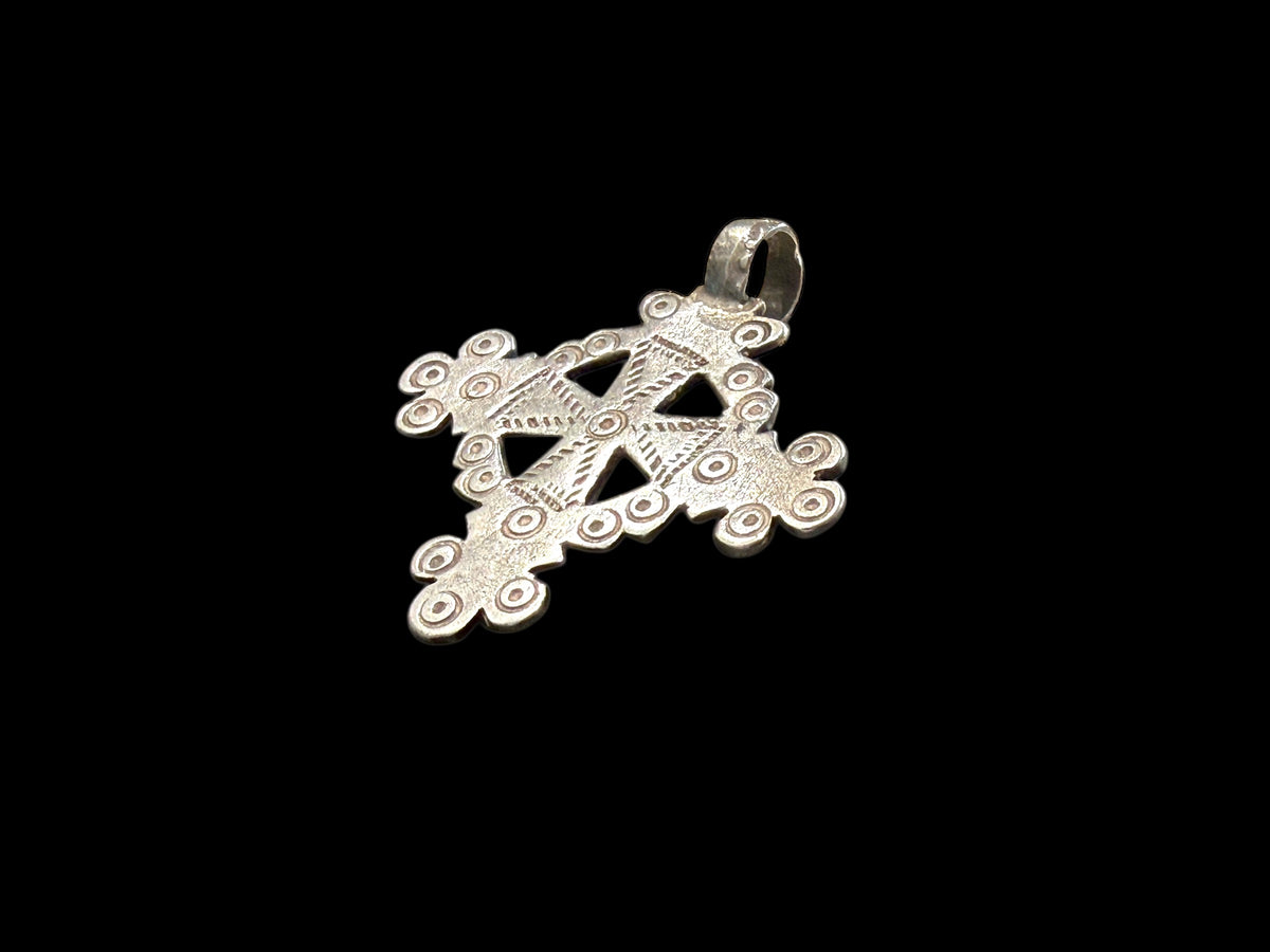 Mid 20th century round Ethiopian silver crucifix, cut from a Marie Therese silver thaler. Almost identical markings on both sides. Small amount of wear at the head of the bail. Height including bail 5.1 cm