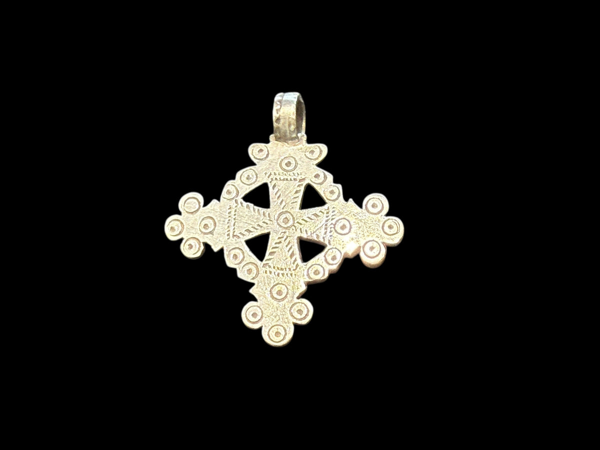 Mid 20th century round Ethiopian silver crucifix, cut from a Marie Therese silver thaler. Almost identical markings on both sides. Small amount of wear at the head of the bail. Height including bail 5.1 cm