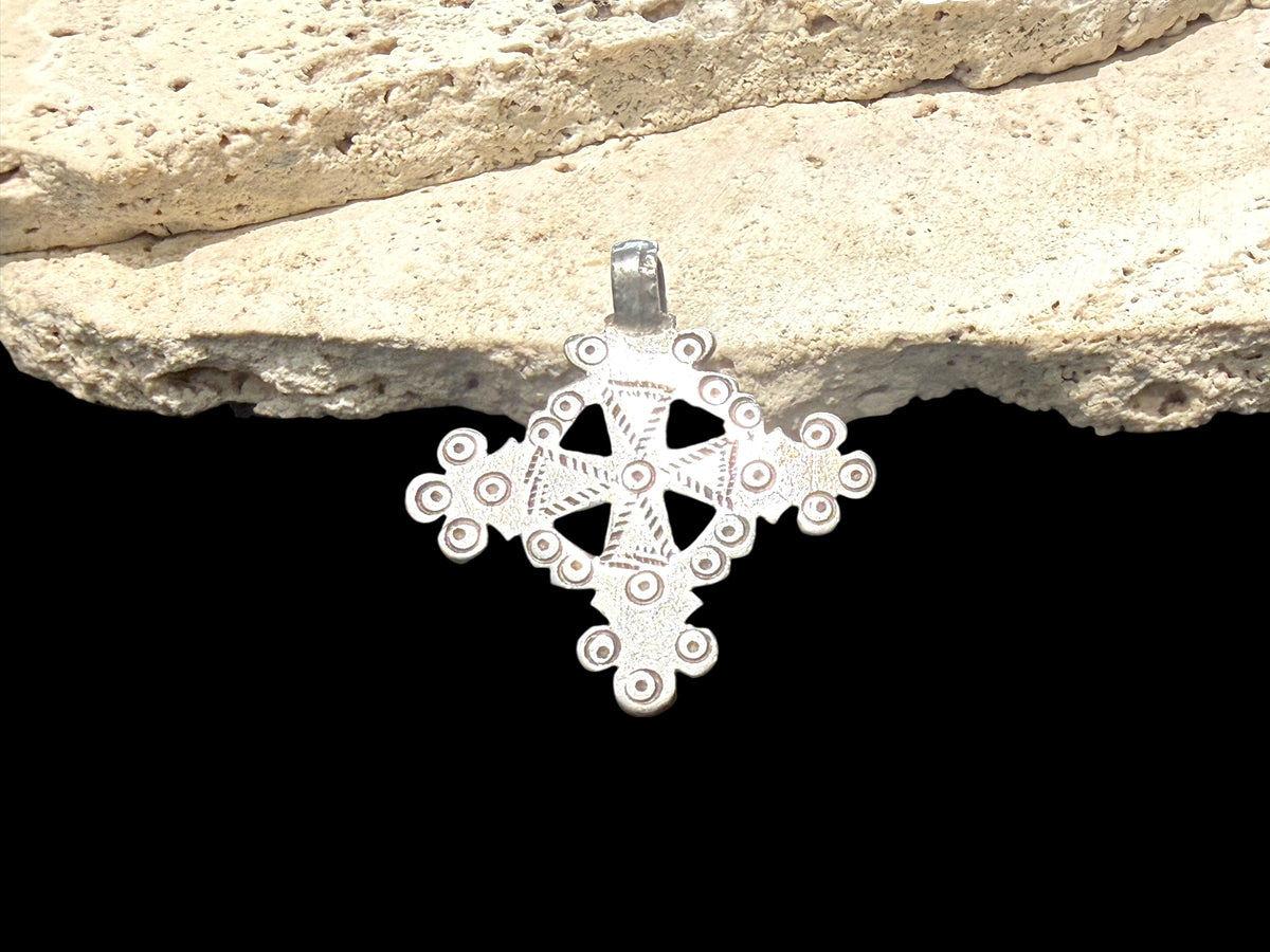 Mid 20th century round Ethiopian silver crucifix, cut from a Marie Therese silver thaler. Almost identical markings on both sides. Small amount of wear at the head of the bail. Height including bail 5.1 cm