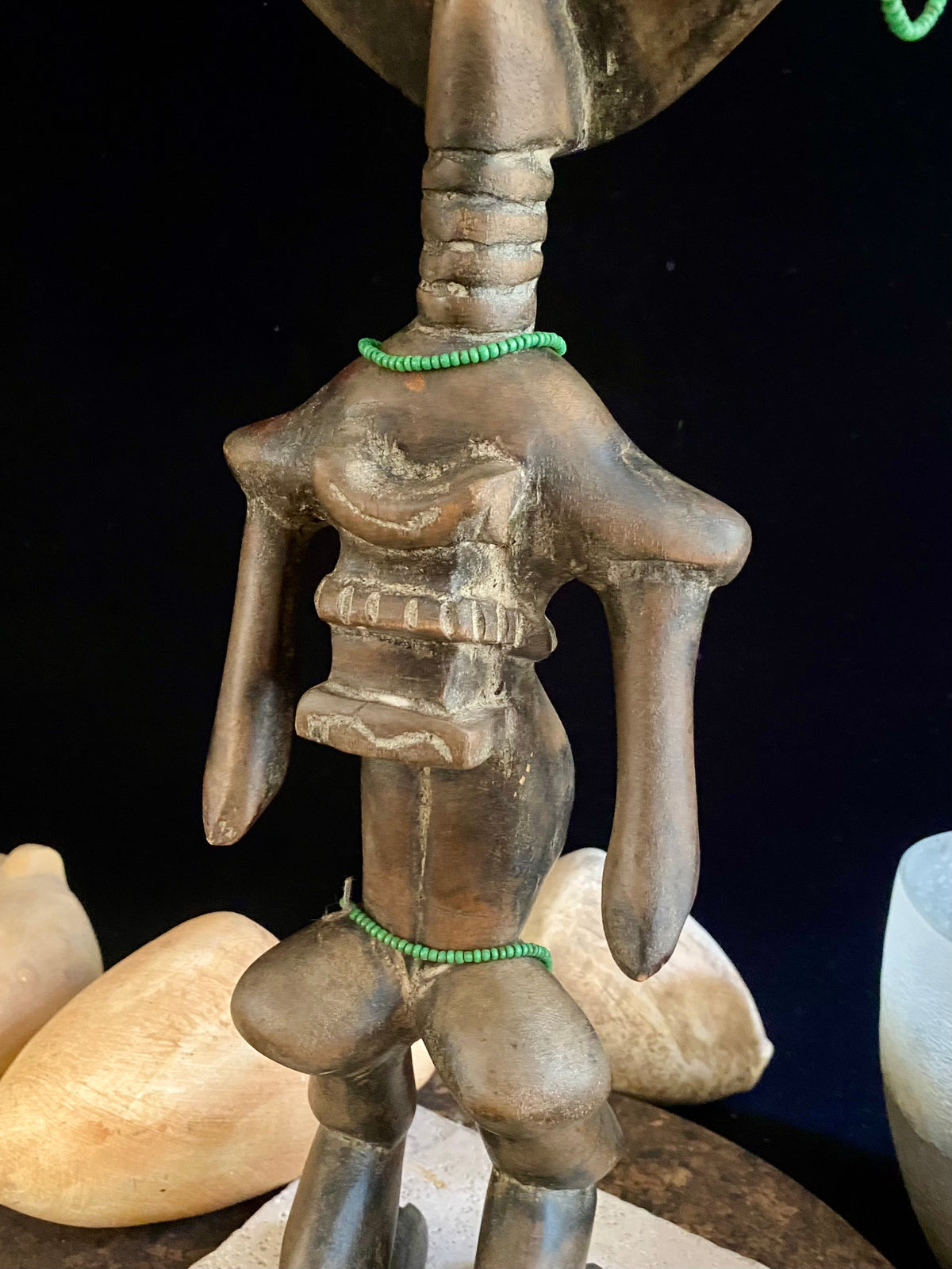 Akuaba or Aquaba Doll, Asante, from Ghana. Mid 20th Century, vintage fertility idol with carved neck rings and beaded decoration and carries a smaller, more traditional akuaba figure on her forehead. She is detailed on the back, wearing a carved baby carrier. Height 45.5 cm