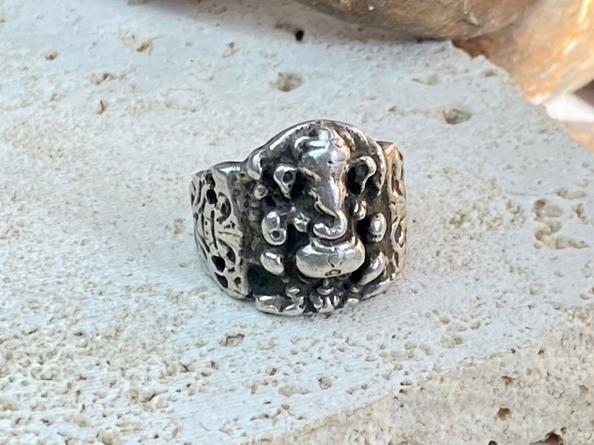 Vintage silver Ganesh ring from Rajasthan, India, weighing over 15 grams. A beautiful depiction of Lord Ganesha with small open piercings to each side of Ganesh and an image of the Tree of Life on the back. This is a stunning silver ring that can worn by men or women. Ganesh: 2 x 1.7 cm Size: 18.25 mm| Size 8