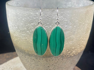 Our elegant earrings feature perfectly matched malachite cabochons set in sterling silver bezels. Finished with sterling silver hooks.