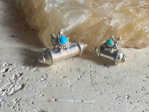 These lovely box pendants open at one end and have plenty of room to place items inside. Two bails complete the look. Sterling silver, finished with a turquoise stone.  Two sizes to choose from