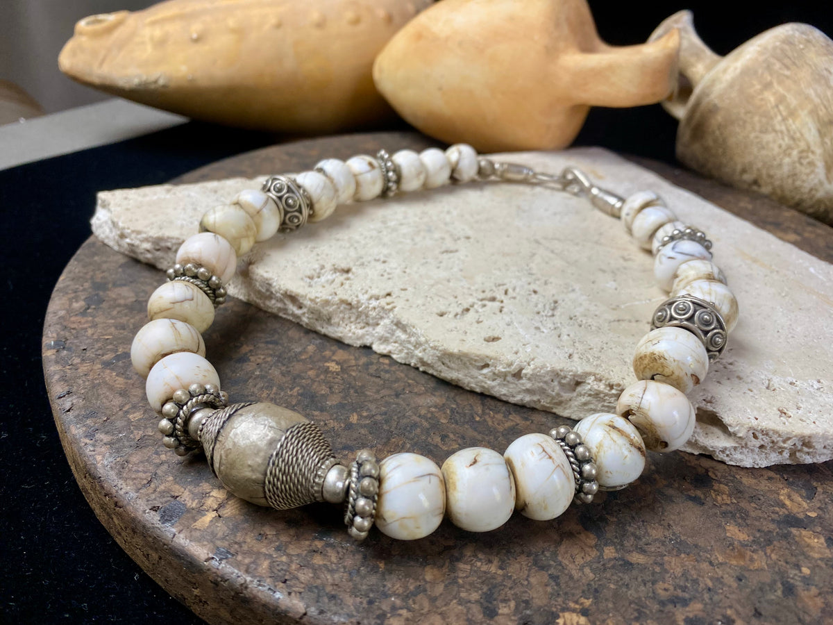 This statement choker necklace inspires Boho chic and features large antique Naga shell beads beads, vintage Indian silver beads and a handmade sterling silver hook. The central bead is an old piece consisting of hand wrapped silver over a wood frame. Length 48 cm