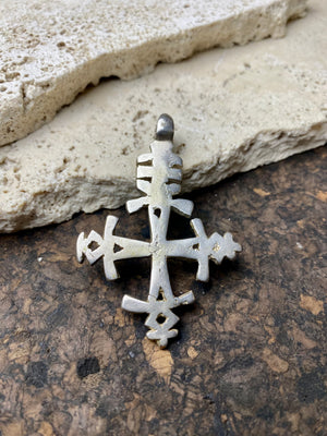 Mid 20th century Ethiopian silver crucifix. This may have been cut from a Marie Therese silver thaler, as the antique ones always are, however I believe that the style is more recent. Tests as silver. Plain on front side, plain back. Some wear at the head of the bail commensurate with its age. A wearable and collectable piece of jewellery.  Measurements: length including bail 6 cm