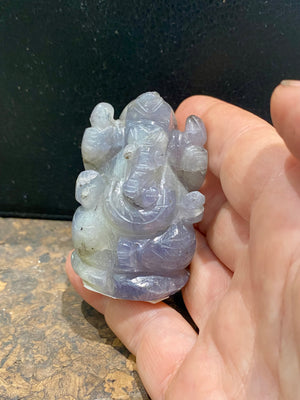 Hand carved from a solid chunk of iolite crystal, our Ganesha statue has a very contemporary feel. Ganesh is the lord of wisdom, remover of obstacles, patron of the the arts and new beginnings. Keeps unwanted influences from your door. Measurements: 5 cm height, width at base 3.5 cm