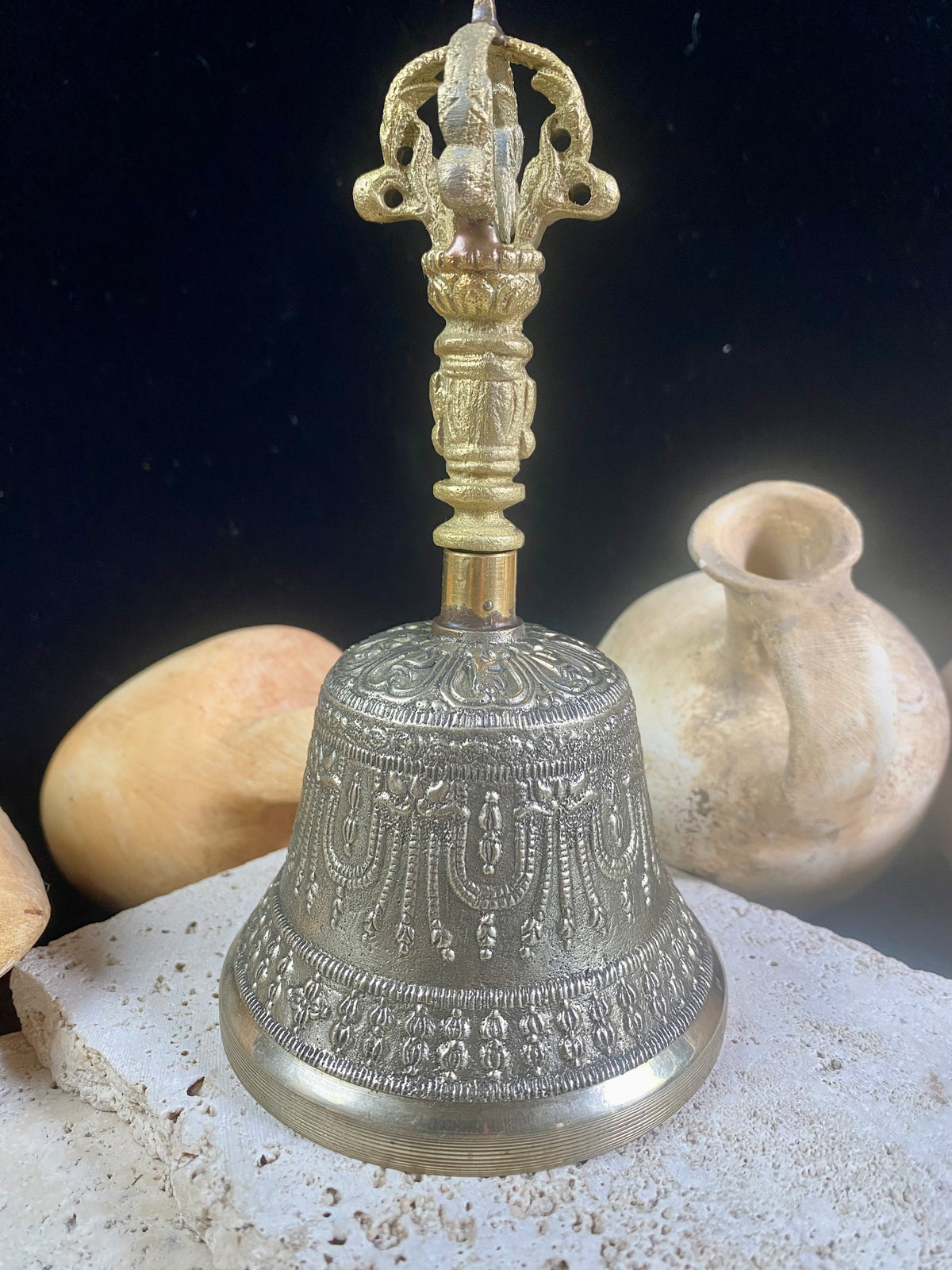 Tibetan Buddhist bells in two sizes. They feature fine detailing, are encircled with the mantra Om Mani Padmi Hum and are topped with the image of the Buddha and the dorje. These very high quality bells have a beautiful tone, the larger is deeper and richer, the smaller is higher and sweeter. Please watch our two videos to hear their sound.  Measurements:  Large: height 16 cm, diameter 9 cm Small: height 13 cm, diameter 7.5