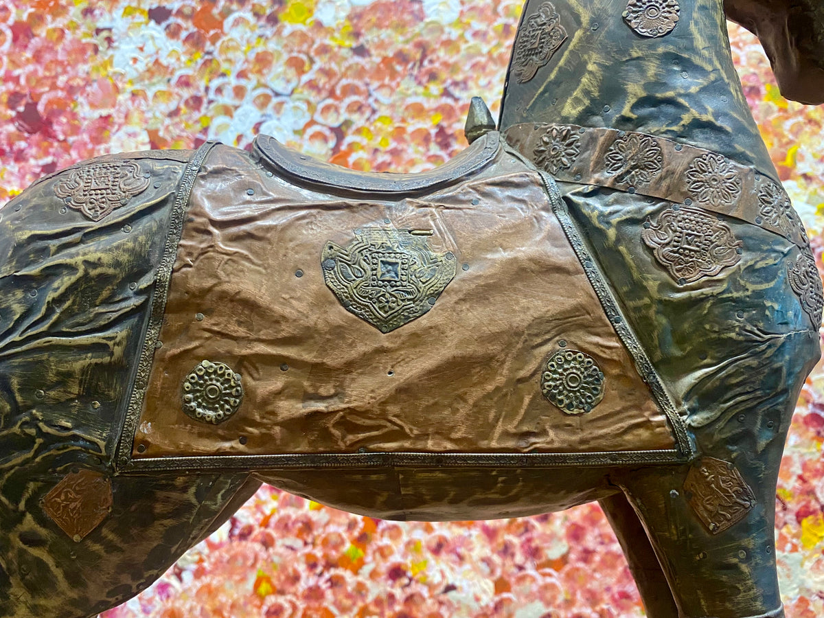 Antique Indian rocking horse. Covered entirely in sheets of embossed brass and copper sheet with floral and ornamental plaques, strap work and highly embossed decoration. Hardwood Early 20th century, southern India. Measurements: height to ear 52 cm, length 40.5 cm, width 13.5 cm.