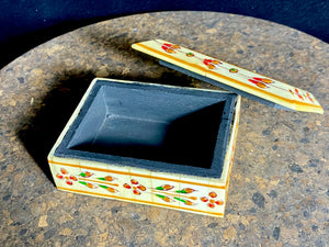 A compact trinket box, hand crafted from wood overlaid with polished hand shaped panels of camel bone, which are then exquisitely hand painted.  Measurements: 10 cm x 7.5 cm, height 4 cm 