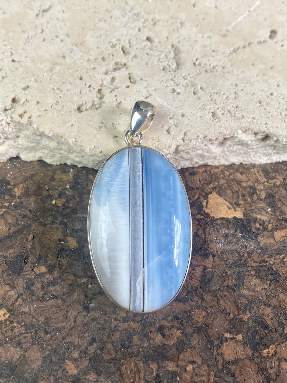 Natural banded blue opal pendants. Set off by sterling silver bezels, topped by generous sized bails large enough to accommodate a thick chain or cord. If you're looking for something a little bit different, this is statement jewellery at its finest.